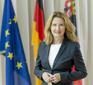 Staatssekretärin Heike Raab vor Europa-, Deutschland- und Rheinland-Pfalz-Flagge